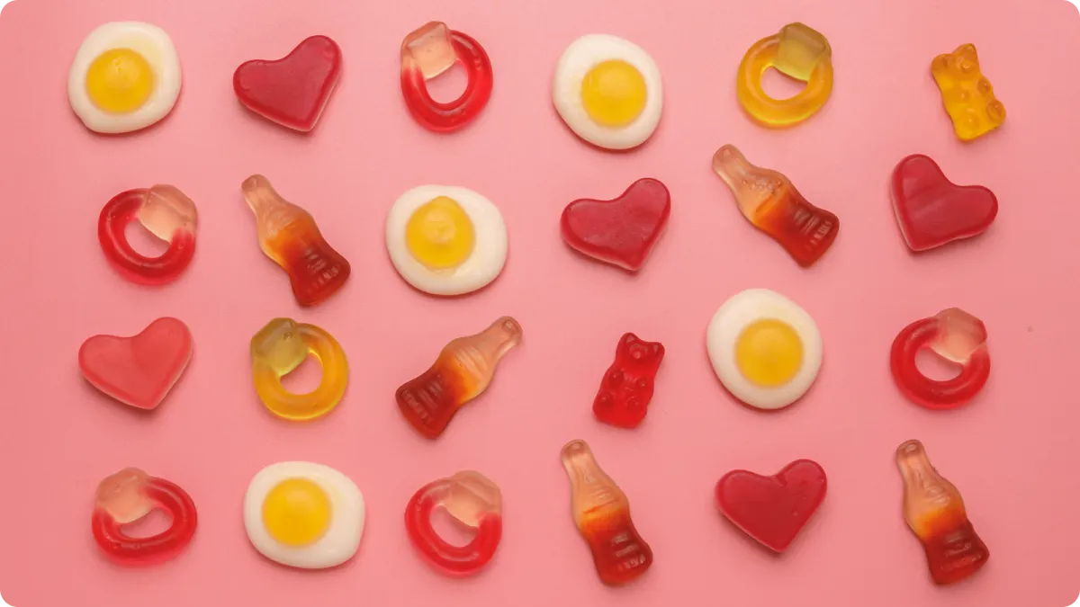 Core gummy ingredients on a workbench: gelatin powder, pectin, glucose syrup, citric acid and finished gummy candies